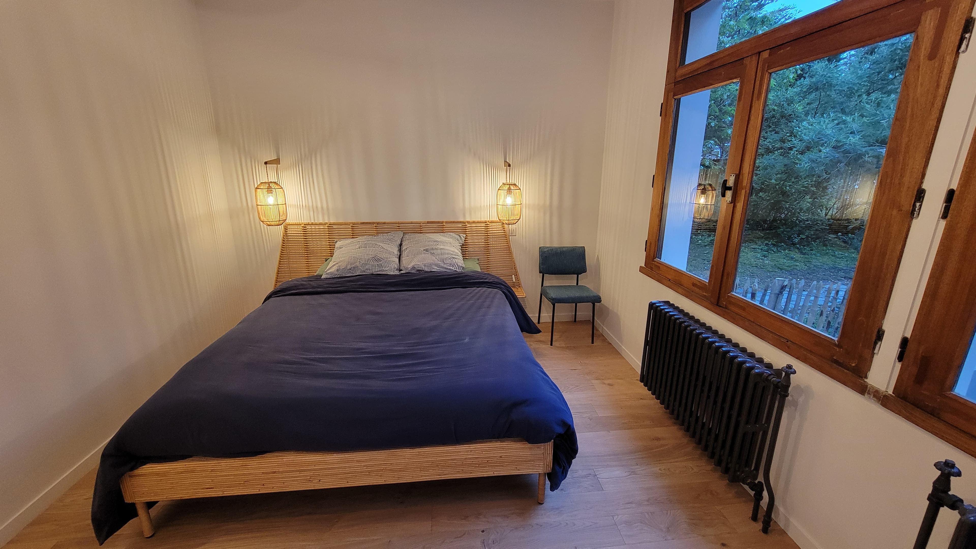 Grande chambre avec lit de 160 x 200 cm (draps en option), lit bébé et coin bureau, donnant sur le jardin devant la maison